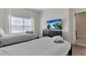 Bedroom with two twin beds, large TV and window at 4838 Romeo Cir, Kissimmee, FL 34746