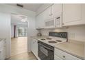 White kitchen with appliances and view to living area at 700 Melrose Ave # K32, Winter Park, FL 32789
