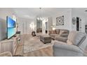 Living room with sofa, armchair, and large TV at 1624 Hawksbill Ln, Saint Cloud, FL 34771