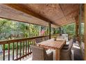 Enjoy a relaxing view from this back porch, featuring a wooden table and chairs at 1205 Sutton Trl, Geneva, FL 32732