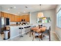 Modern kitchen with wood cabinets, granite countertops, and an island with seating at 491 Las Fuentes Dr, Kissimmee, FL 34746