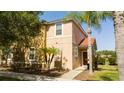 Tan two-story house with palm trees and a walkway to the entrance at 491 Las Fuentes Dr, Kissimmee, FL 34746