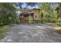 Rustic two-story home on stilts with a wooden exterior and large deck at 1205 Sutton Trl, Geneva, FL 32732