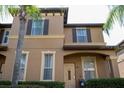 Two-story tan house with a traditional style and landscaping at 1002 Calabria Ave, Davenport, FL 33897