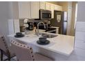 Modern kitchen with white cabinets and stainless steel appliances at 1002 Calabria Ave, Davenport, FL 33897
