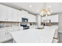 Modern kitchen with white cabinets, quartz countertops, and stainless steel appliances at 1870 Sawyer Palm Pl, Kissimmee, FL 34747