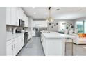 Modern kitchen with white cabinets, quartz countertops, and stainless steel appliances at 1870 Sawyer Palm Pl, Kissimmee, FL 34747