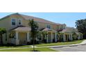 Row of townhomes with yellow exteriors, landscaping, and parking at 17401 Serenidad Blvd, Clermont, FL 34714