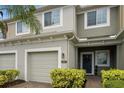 Two-story townhome with a two-car garage and manicured landscaping at 2663 River Landing Dr, Sanford, FL 32771