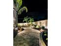 Landscaped backyard with a lighted pathway at night at 318 Stone Castle Loop, Lady Lake, FL 32159
