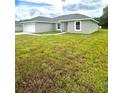 Newly constructed home with gray siding and a grassy lawn at 12202 Se 87Th Ct, Belleview, FL 34420