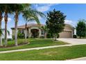 One-story home with palm trees and landscaping at 1905 Sanderling Dr, Clermont, FL 34711