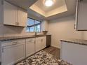 Modern kitchen featuring white cabinets and granite countertops at 7609 Rose Ave, Orlando, FL 32810