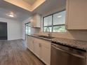 Renovated kitchen with stainless steel appliances and granite countertops at 7609 Rose Ave, Orlando, FL 32810
