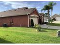 Red house with a two car garage and green lawn at 514 Tree Shore Dr, Orlando, FL 32825