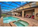 Inviting pool and spa with covered patio; perfect for outdoor entertaining at 8810 Macapa Dr, Kissimmee, FL 34747