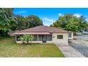 Front view of charming ranch home with mature landscaping at 1404 E Alfred St, Tavares, FL 32778