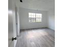 Simple bedroom with grey vinyl flooring and large window at 5329 Hansel Ave # B-4, Edgewood, FL 32809