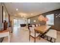 Open concept dining area with a large wooden table and modern lighting at 4063 Lana Ave, Davenport, FL 33897