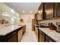 Modern kitchen with granite countertops and dark brown cabinetry at 4063 Lana Ave, Davenport, FL 33897