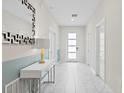 Clean entryway with white walls, tile floors and modern decor at 1158 Drop Ln, Davenport, FL 33896
