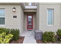 Modern front entrance with red door and glass panels at 1158 Drop Ln, Davenport, FL 33896