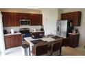Modern kitchen with stainless steel appliances and an island at 462 Hamlet Loop, Davenport, FL 33837