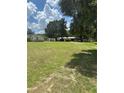 Spacious front yard with two houses and mature trees at 7400 E Hwy 25, Belleview, FL 34420