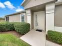 Front entryway with a white door and neatly trimmed landscaping at 9597 Sw 70Th Loop, Ocala, FL 34481