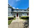 Two-story townhome with a red door and a neatly landscaped front yard at 2606 Lodi Cir # 105, Kissimmee, FL 34746