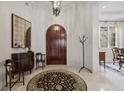 Elegant entryway with arched wooden door and decor at 11261 Macaw Ct, Windermere, FL 34786