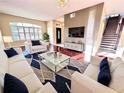 Bright living room with hardwood floors, white sofas, and a large TV at 122 Stone Gable Cir, Winter Springs, FL 32708