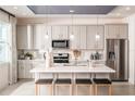 Modern kitchen with white cabinets, center island, and stainless steel appliances at 2424 Park Ridge St, Apopka, FL 32712