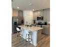 Modern kitchen with gray cabinets, quartz countertops and island at 2021 Crape Jasmine Ln, Orlando, FL 32824