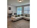 Open living space with a white sectional sofa and dining area at 2021 Crape Jasmine Ln, Orlando, FL 32824