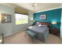 Main bedroom with teal accent wall and large window at 7762 Linkside Loop, Reunion, FL 34747