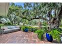 Brick patio with a comfy couch and lush landscaping under a large oak tree at 727 Park Lake Cir, Orlando, FL 32803