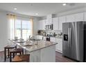 Modern kitchen featuring granite countertops, stainless steel appliances, and an island with seating at 2738 Flushing Dr, Apopka, FL 32703