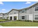 Row of townhouses with gray siding, landscaping, and walkway at 936 Paradise Dr, Davenport, FL 33897