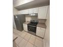 Condo kitchen with stainless steel appliances and light wood cabinets at 5578 Metrowest Blvd # 107, Orlando, FL 32811