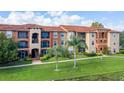 Attractive two-story condo building with lush landscaping and palm trees at 5578 Metrowest Blvd # 107, Orlando, FL 32811