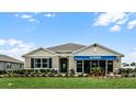 Tan house with blue accents and landscaped yard at 3901 Botancial Court, Sanford, FL 32773