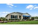 Tan house with blue accents and landscaped yard at 3901 Botancial Court, Sanford, FL 32773