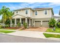 Two-story house with tan siding, two-car garage, and landscaping at 5994 Painted Leaf Dr, Winter Garden, FL 34787