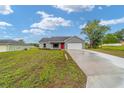 Newly built home with a red door and spacious driveway at 43 Sequoia Trl, Ocklawaha, FL 32179