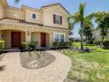 Two-story townhome with red shutters, a landscaped yard and brick pathway at 4791 Terrasonesta Dr, Davenport, FL 33837