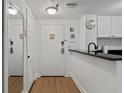 Apartment entryway with mirror, wood floors, and white door at 6165 Carrier Dr # 1206, Orlando, FL 32819