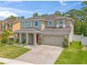 Two-story house with red door, two-car garage, and landscaped yard at 4862 Rockvale Dr, Kissimmee, FL 34758