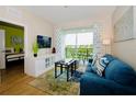 Bright living room with a blue sofa, balcony access, and hardwood floors at 4114 Breakview Dr # 406, Orlando, FL 32819