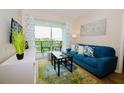 Living room with blue sofa, balcony access, and hardwood floors at 4114 Breakview Dr # 406, Orlando, FL 32819